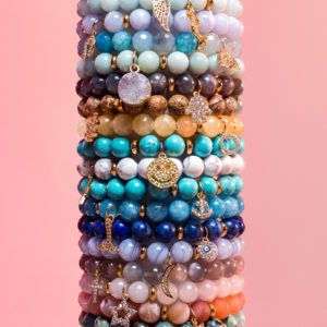 Collection of beaded bracelets each featuring different kinds of beads and different charms